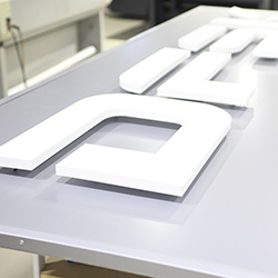 insegna a luce riflessa con logo a rilievo